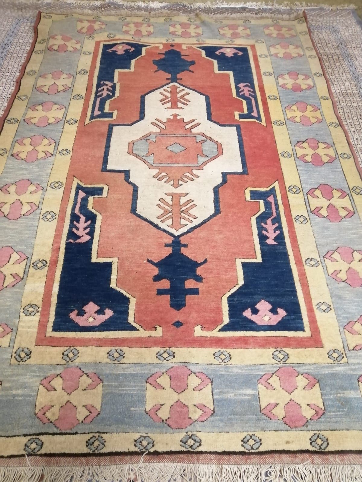An Afghan Kazak rug, the red and blue ground field centred by an ivory cruciform medallion, 277 x 185cm